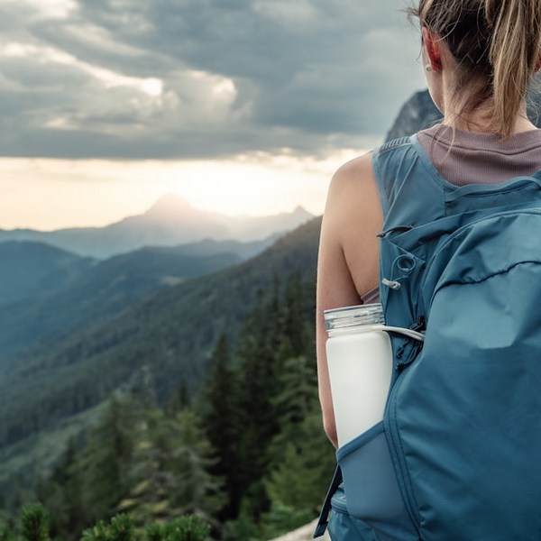 a woman with a backpack on a mountain