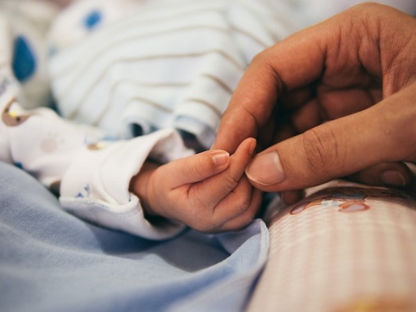 a close-up of a hand holding a baby