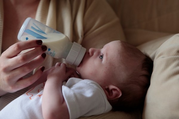 a baby being fed by a bottle