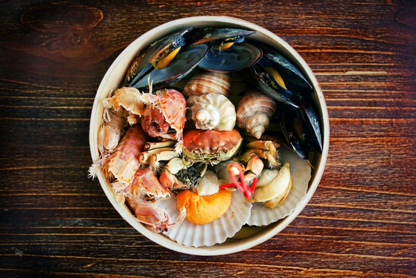 a bowl of seafood on a wood table