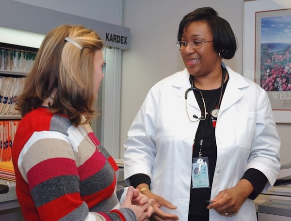 a woman in a white coat talking to a woman