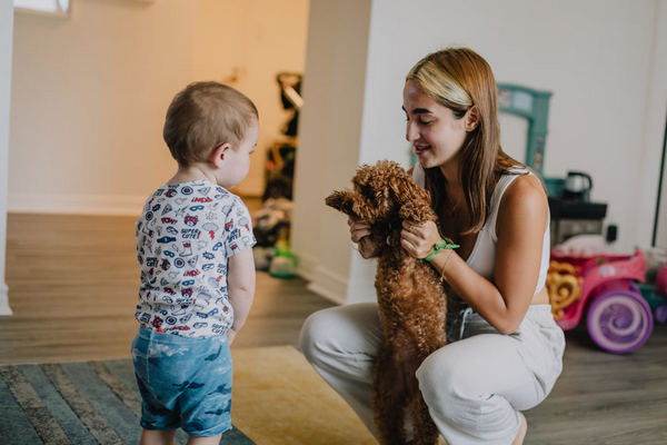 a woman holding a dog and a child