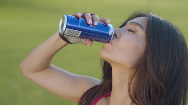 woman drinking from can