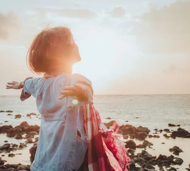 woman embracing beach sunlight