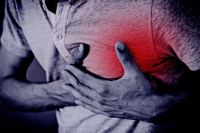 man clasping chest in pain