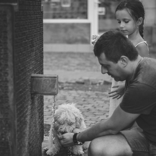 a man and a girl petting a dog