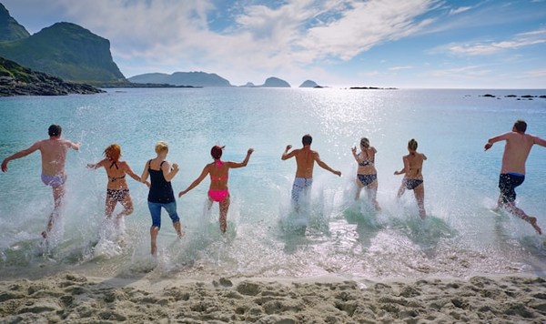 a group of people running into the water