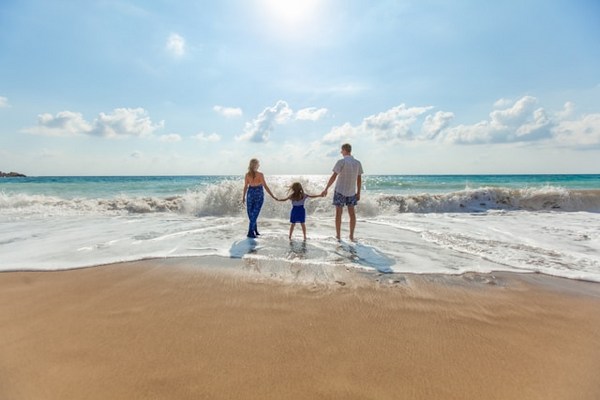 a man and woman holding hands on a beach