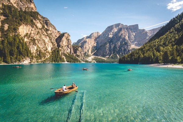 a group of boats in a body of water with mountains in the background with Mount Pinatubo in the background