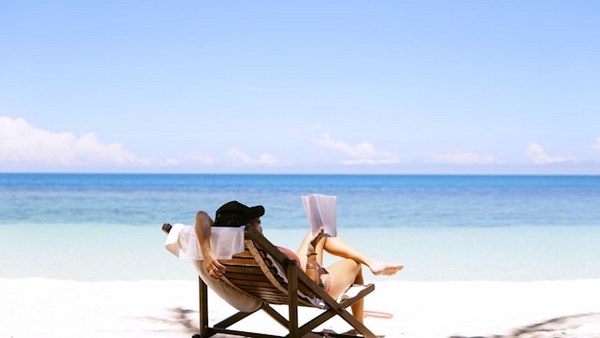 a woman sitting in a chair on a beach