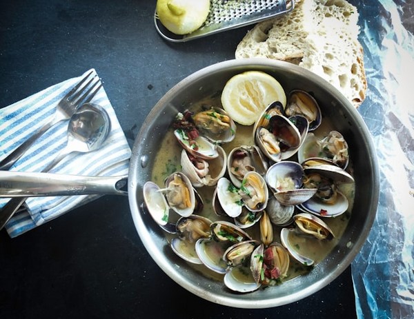 a pan of clams and a lemon